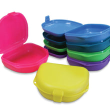 Assortment of Oro retainer boxes in various colors including orange, blue, yellow, and white with ventilated design for retainers and aligners